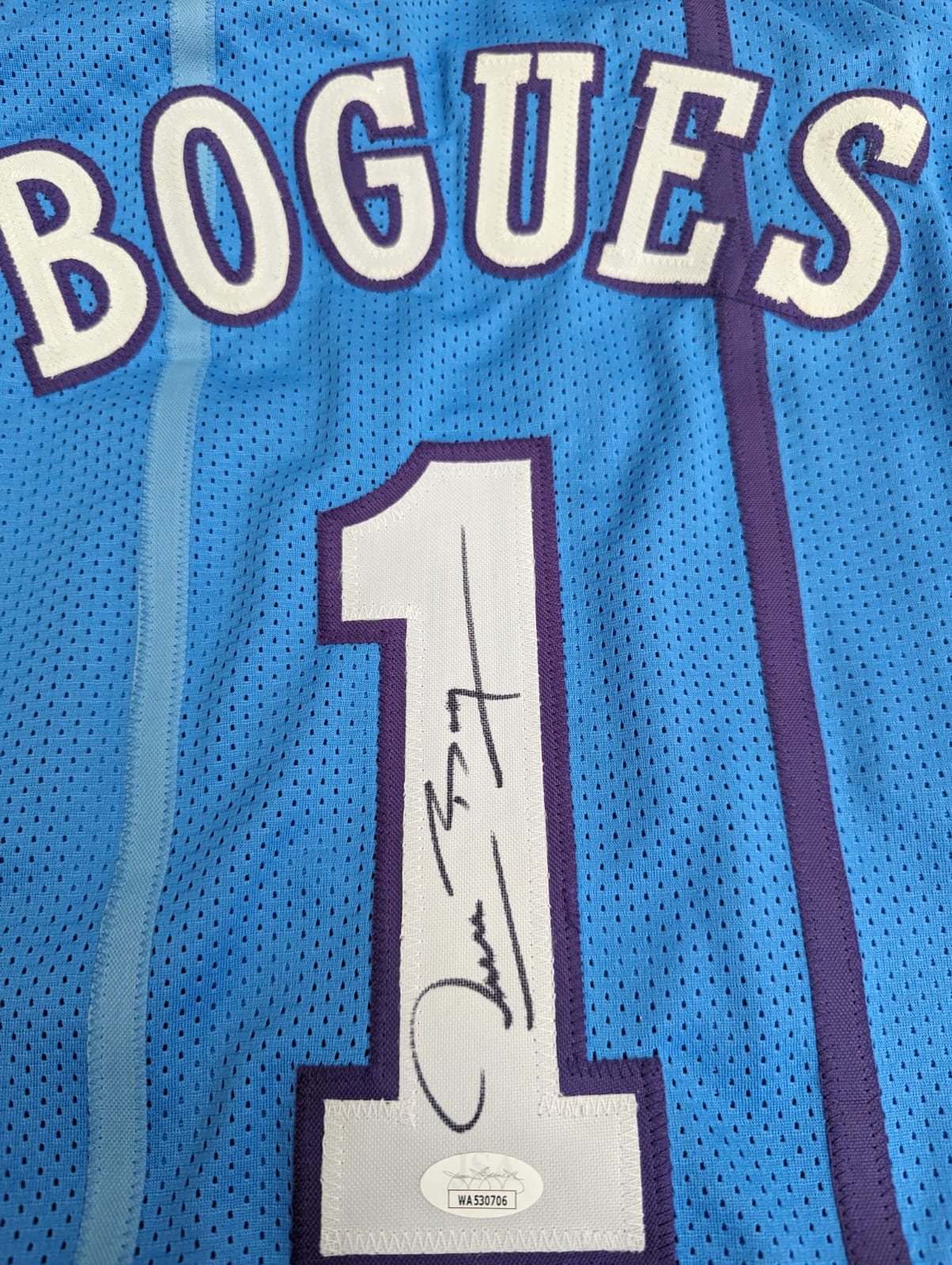 Playera autografiada por Muggsy Bogues firma autentificada por la compañía JSA con el número WA530706