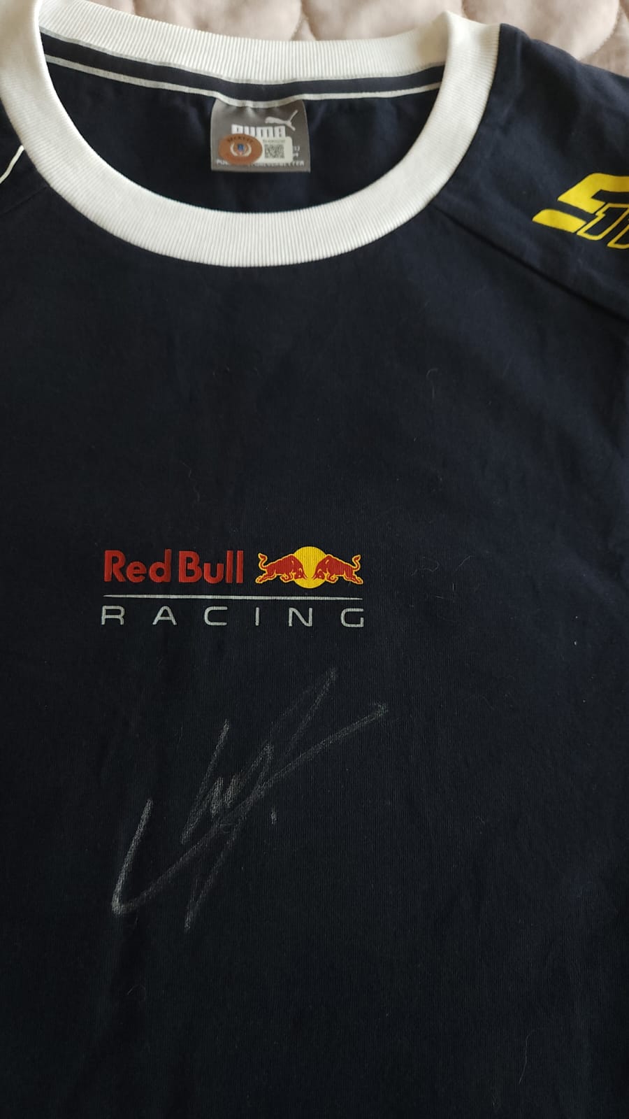 Playera autografiada por Sergio "Checo" Pérez firma autentificada por la compañía Beckett con el número BH060230.