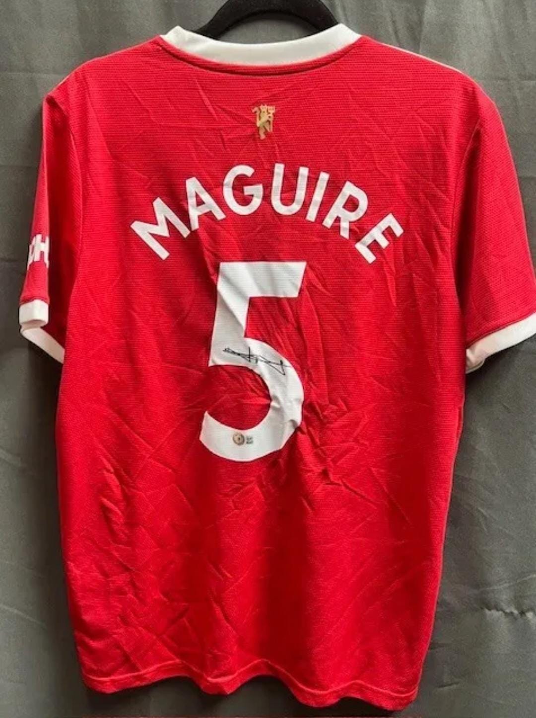 Playera autografiada por Harry Maguire firma autentificada por la compañía Beckett con el número BB94779.