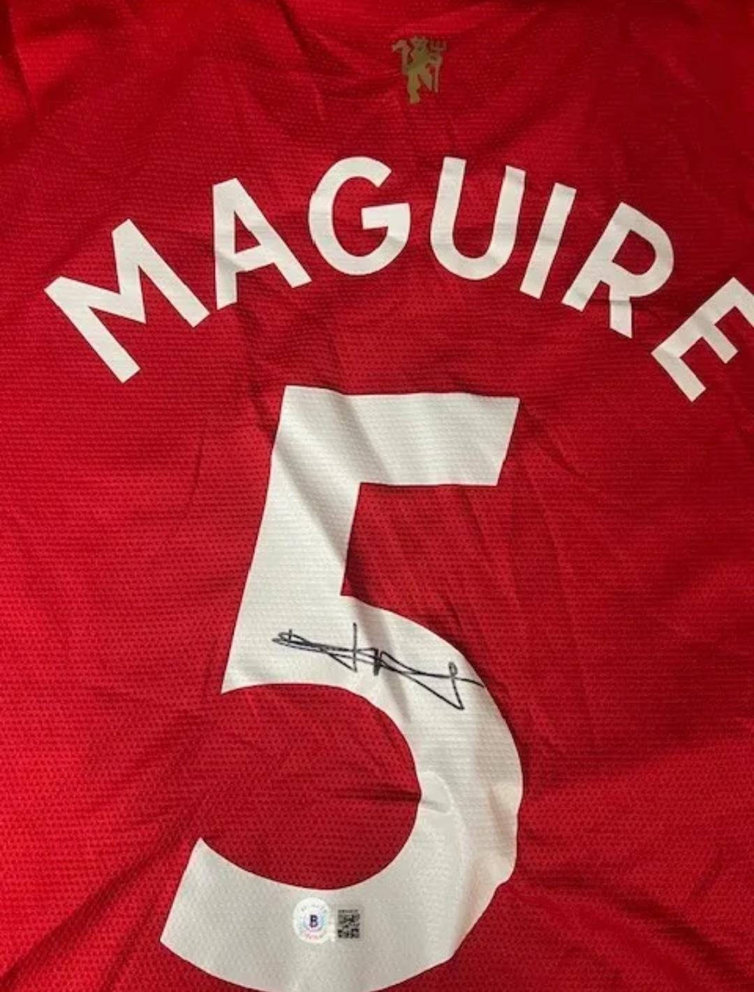 Playera autografiada por Harry Maguire firma autentificada por la compañía Beckett con el número BB94779.