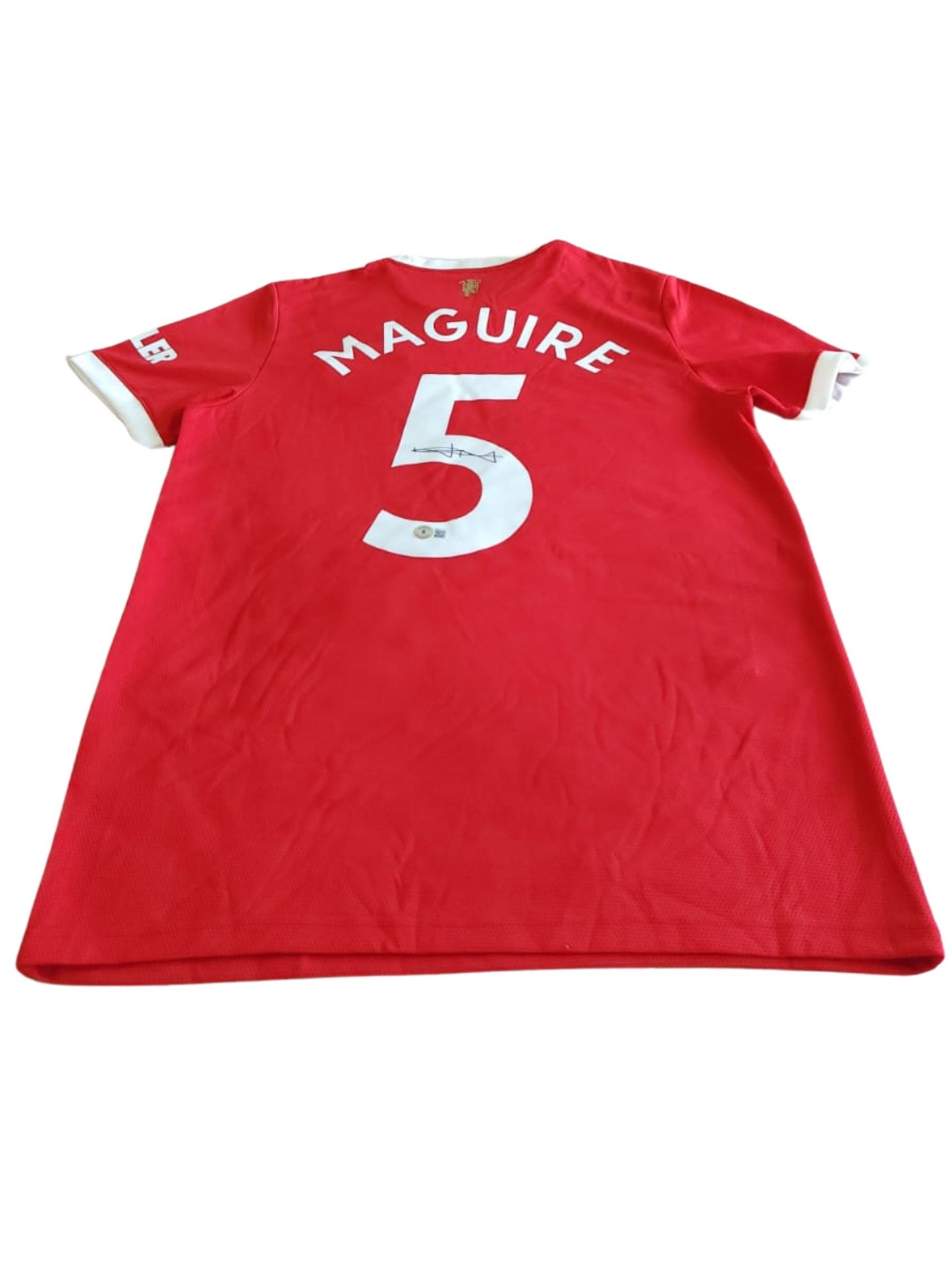 Playera autografiada por Harry Maguire firma autentificada por la compañía Beckett con el número BB94779.