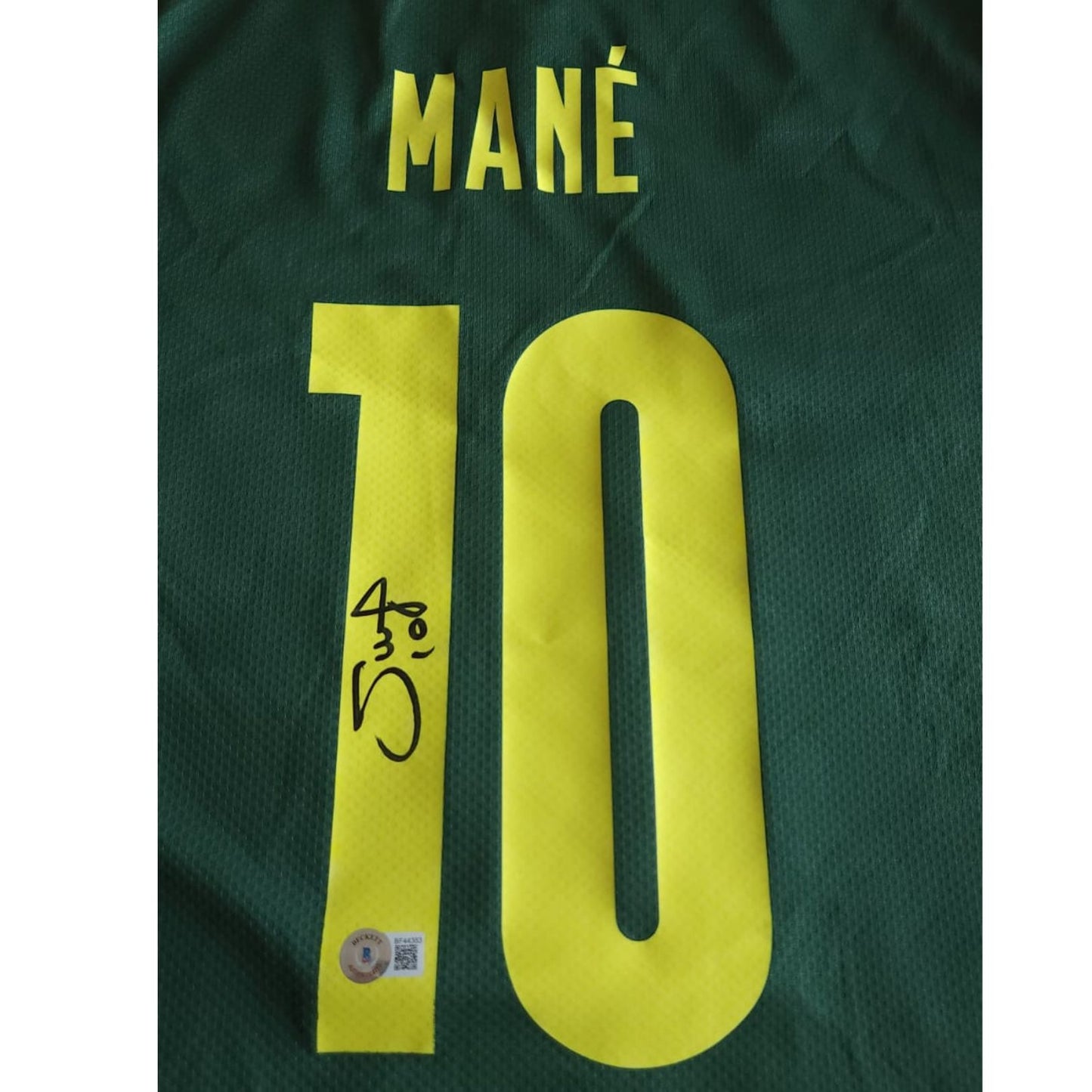 Playera autografiada por Sadio Mané firma autentificada por la compañía Beckett con el número BF44383.