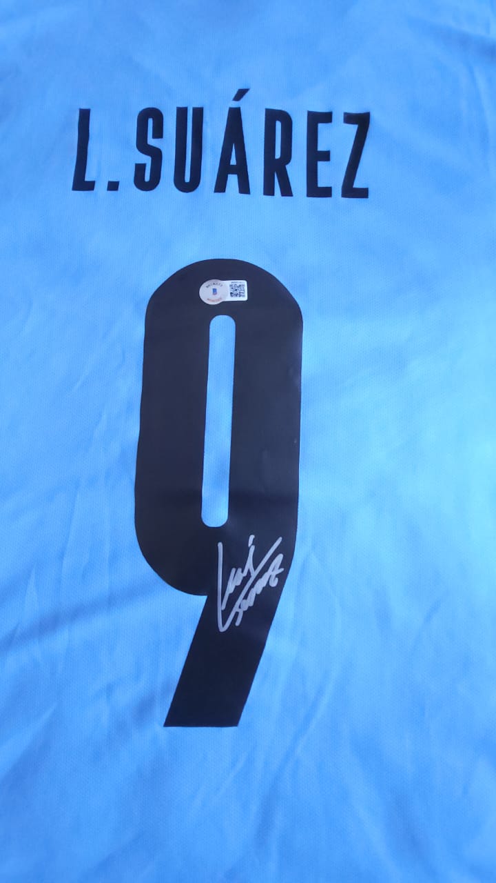 Playera autografiada por Luis Suárez firma autentificada por la compañía Beckett con el número WS03427.