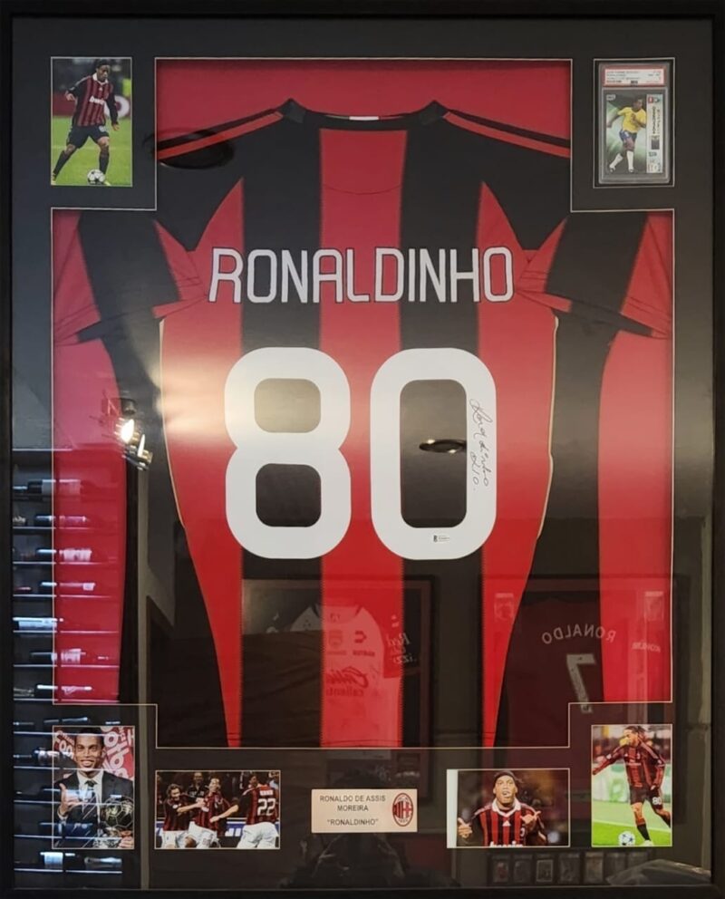 Ronaldinho Playera AC Milan autografiada con tarjeta Enmarcada firma autentificada por la compañía Beckett con el número WH48975.